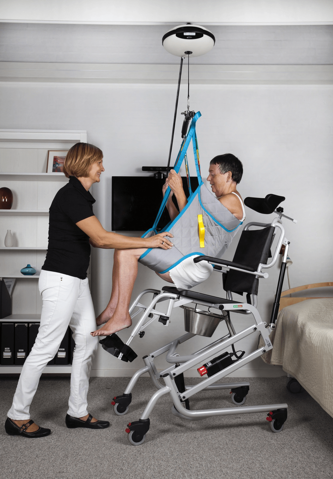 Patient and carer using a ceiling hoist